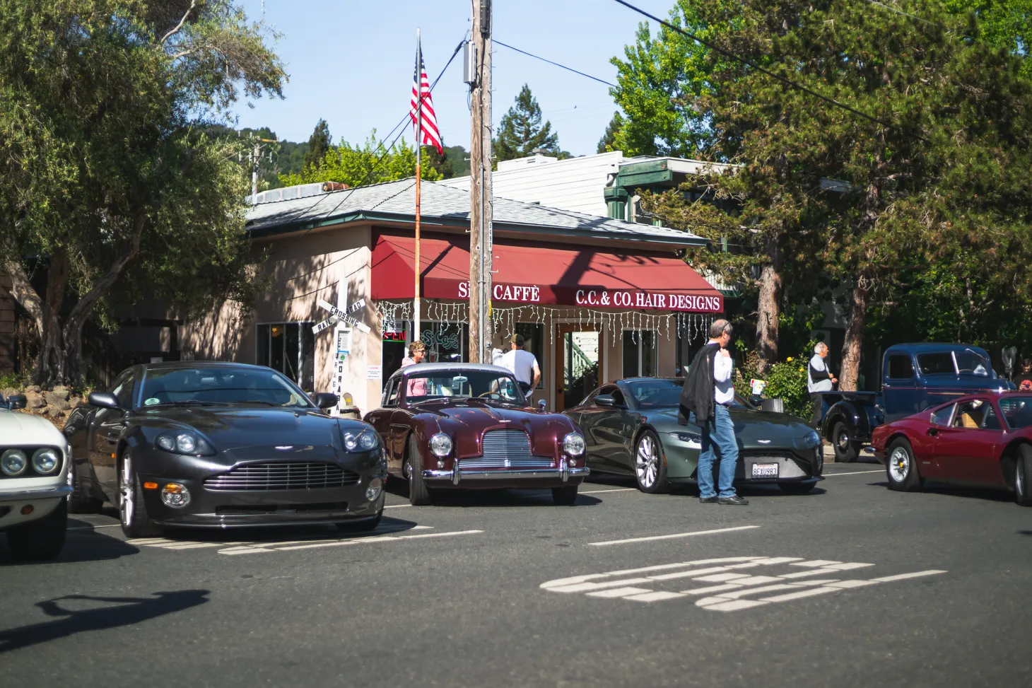 A group of cars parked in front of a restaurant on the coast.
